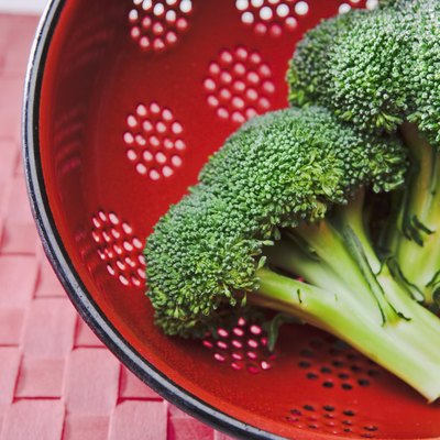 Broccoli crowns in red colander