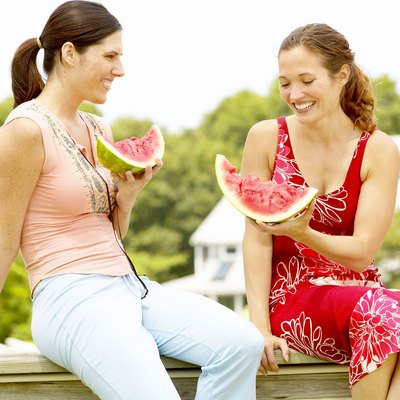 Women eating watermelon outdoors