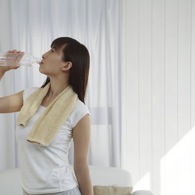 Young Woman Drinking Bottle of Water, Side View