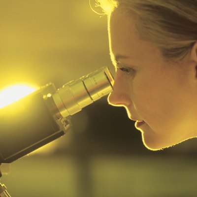 Woman scientist looking through microscope