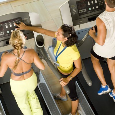 Instructor adjusting treadmill