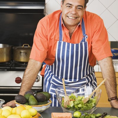 Middle-aged Hispanic man next to food in kitchen