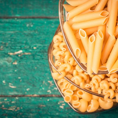 Various mix of pasta on wooden rustic background.