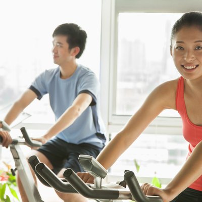 Young people on stationary bikes exercising in the gym