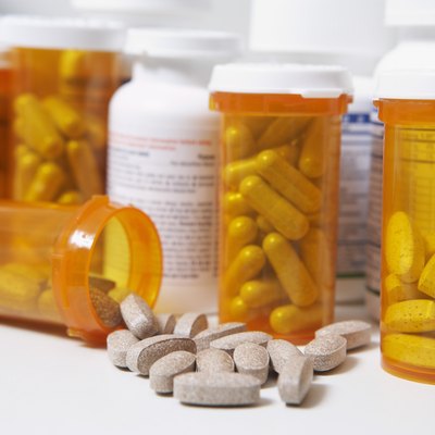 Bottles of pills, one spilling, close-up