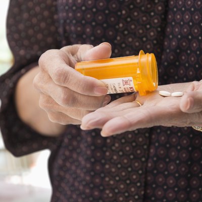 Mixed race woman holding medication pills