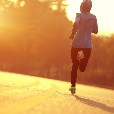 young fitness woman runner athlete running at sunrise road