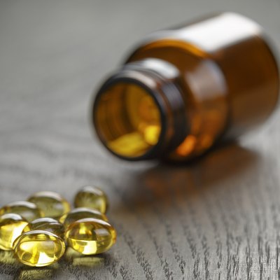 fish oil capsules with bottle on wooden table