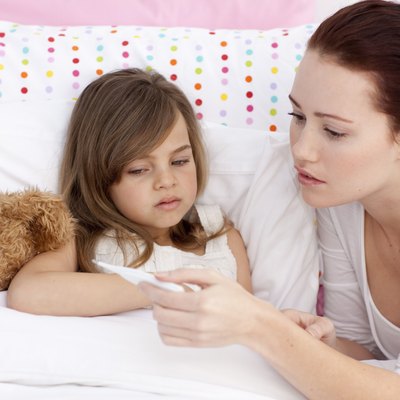 Mother taking sick daughter's temperature