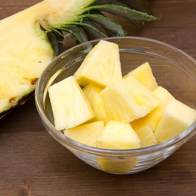 Pineapple cubes on bowl on wood