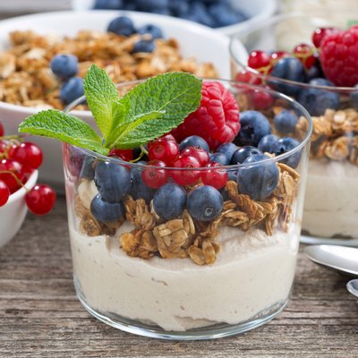 dessert with sweet cream, fresh berries and granola, closeup
