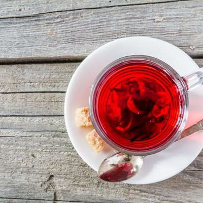Hibiscus tea in glass cup, rustic wood background