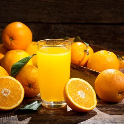 glass of orange juice with fresh fruits on wooden background