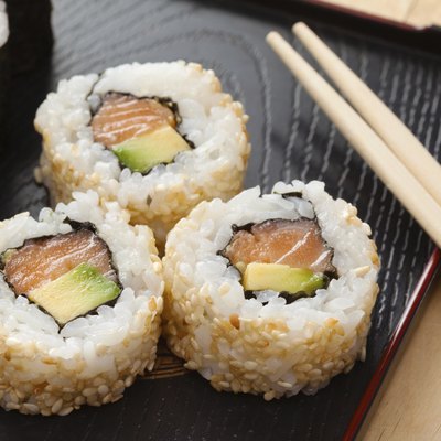 sushi rolls on black plate and chopsticks