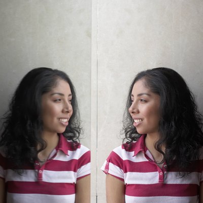 Side profile of a young woman looking at her reflection