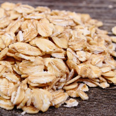 Heap of oat flakes on wooden background