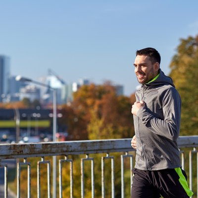 happy young man running over city bridge
