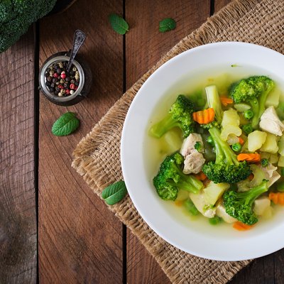 Chicken soup with broccoli, green peas, carrots and celery