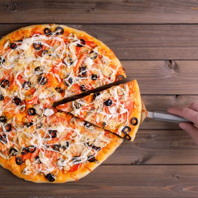 Pizza with cheese and pizza paddle
