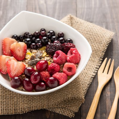Oatmeal in bowl topped with fresh blueberries, cranberries, stra