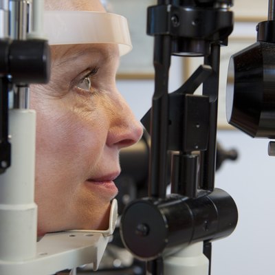 Woman getting eye exam with a slit lamp