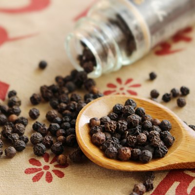 Black pepper seeds spills out of bottle