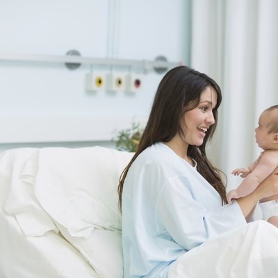 Happy mother holding a baby boy in diaper