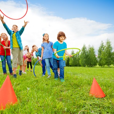 Happy children throw colorful hoops on cones