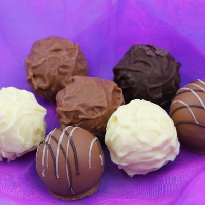 Assorted chocolates, pralines and truffles on purple background