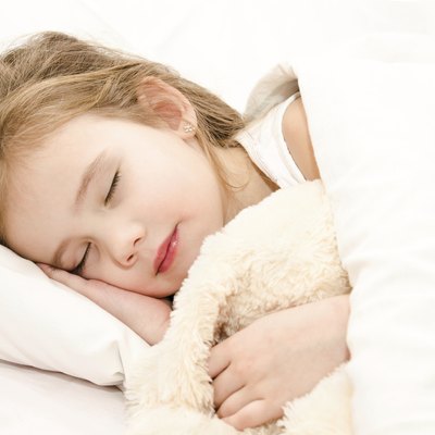 Adorable little girl sleeping in her bed