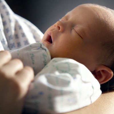 close up of a caucasin newborn in its mothers arm