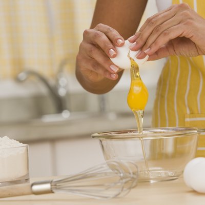 Woman breaking egg into bowl