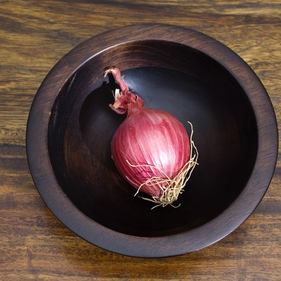 Red onion in wooden bowl