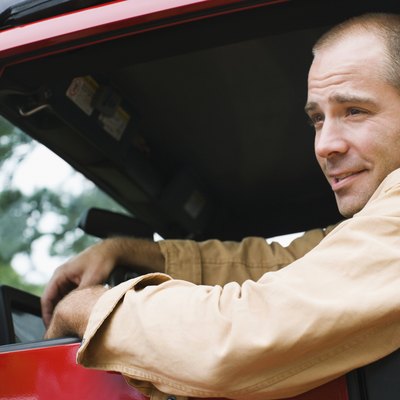 Man driving a jeep and smiling