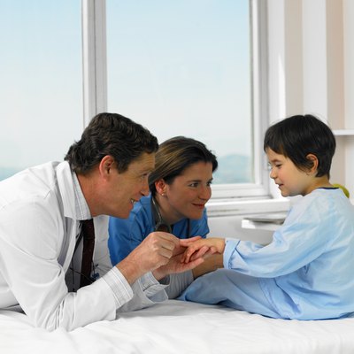 Two doctors with patient sitting on hospital bed