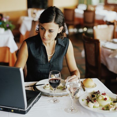 Businesswoman using laptop at restaurant table
