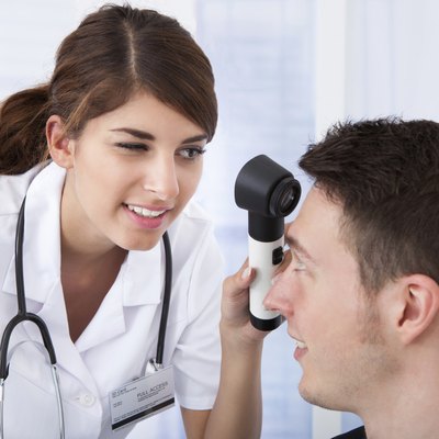 Doctor Examining Businessman With Dermoscope