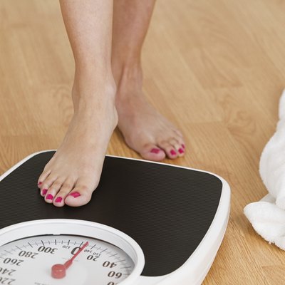 Young woman stepping on a weighing scale