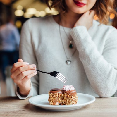Woman eating cake in cafe