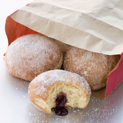 Bag Of Raspberry Jam Doughnuts With A Bite Taken