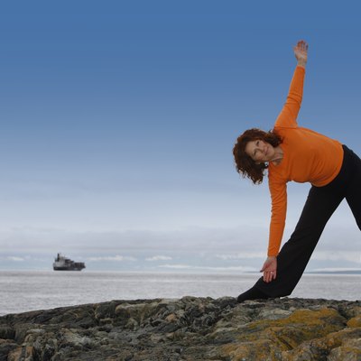 Woman stretching on a rocky beach