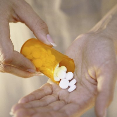 Person holding a vial of tablets