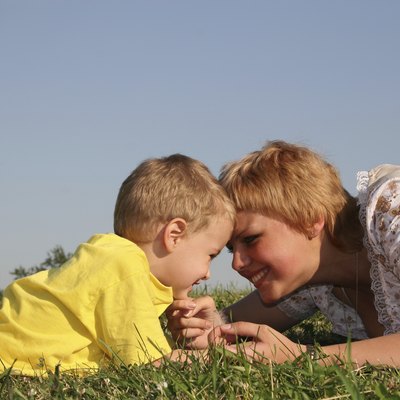mother with boy lies on meadow