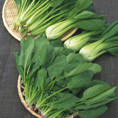 Image of Spinach and Chingensai Lying on a Wooden Plate, High Angle View