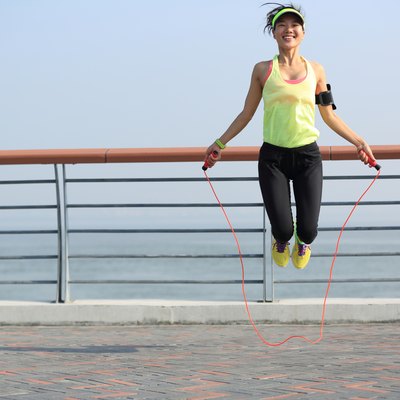 young fitness woman jumping rope at seaside