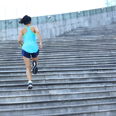 young sports woman running up on stone stairs