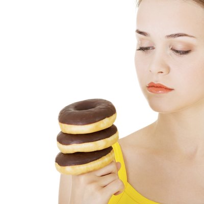 Woman with a pile of doughnuts.