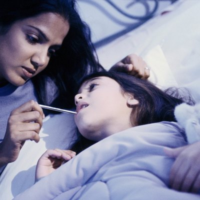 portrait of mother taking daughters temperature
