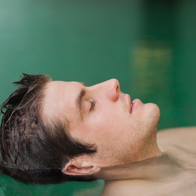 Handsome man floating in the pool