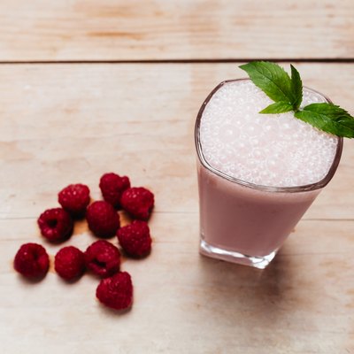 Raspberry smoothie fresh blended on summer wood table